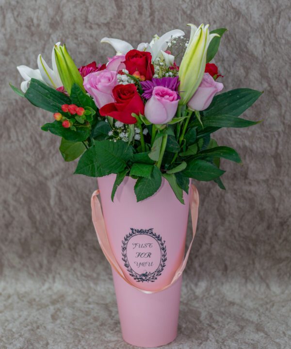 Pink & Red Roses, Tiger Lilies, Berries Flowers and Baby Breath in a Pink Vase.